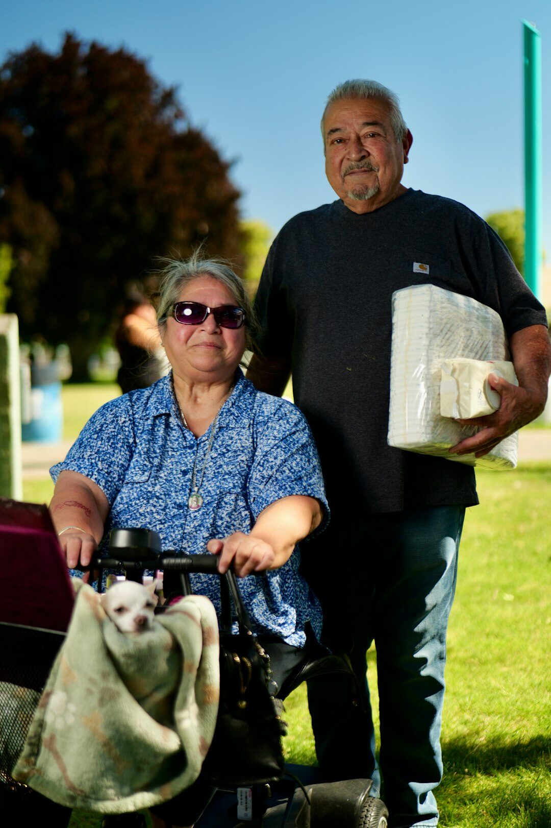 Staff member helping an elderly visitor with paperwork at a desk
